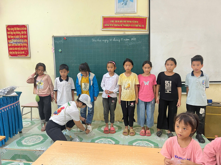 Chị Nguyễn Thị Diễm Phương tận tay thử giày dép cho học sinh Điểm trường Pù Lùng. 8b44acf731689736ce79.jpg