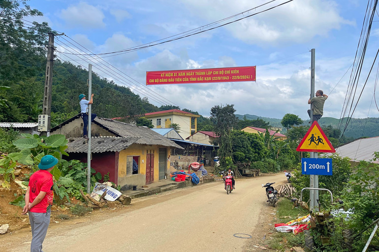 Cán bộ xã Thượng Ân treo băng rôn nhân kỷ niệm 81 năm Ngày thành lập Chi bộ Chí Kiên. 2.jpg