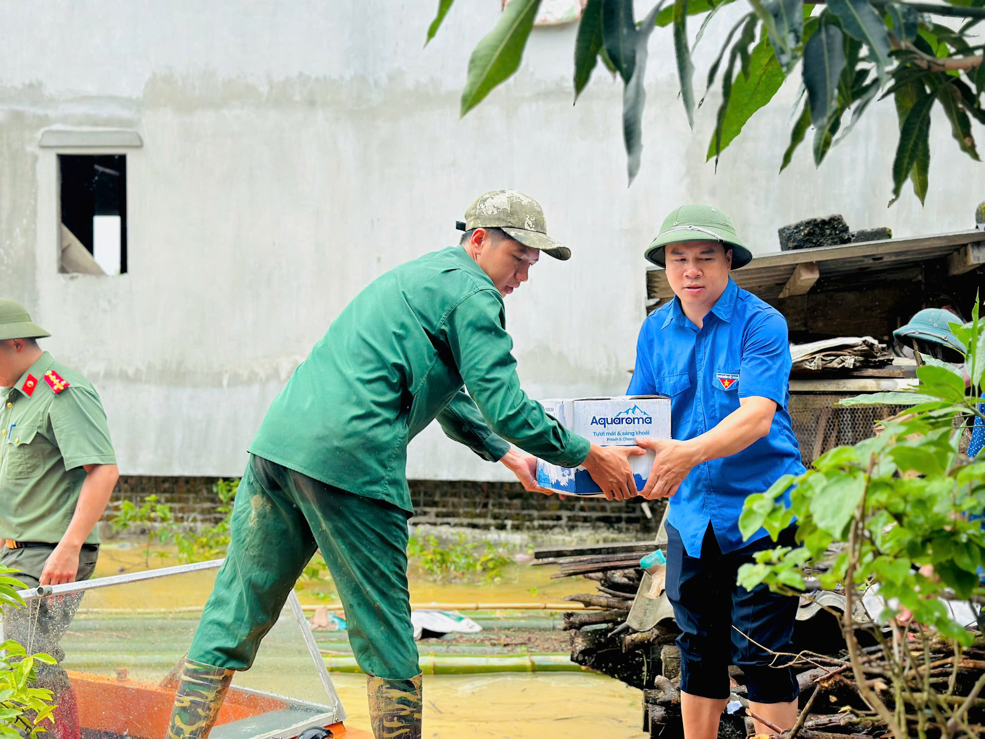 Hỗ trợ người dân vận chuyển nước uống đến các gia đình bị cô lập do nước lũ ở xã Nam Cường. z5820514141110_7e51a54a2640e7d63acb7fd030d27c40.jpg