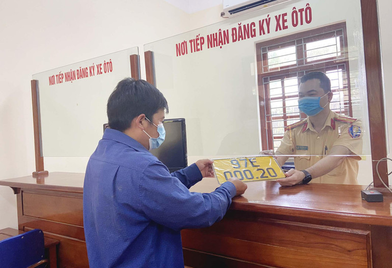Cán bộ Đội Đăng ký, quản lý phương tiện giao thông cơ giới đường bộ, Phòng CSGT Công an tỉnh trả biển số cho chủ phương tiện kinh doanh vận tải.