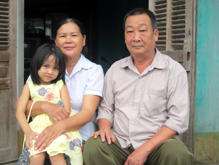 Anh hùng Hà Văn Vấn cùng vợ và cháu nội tại xã Nông Hạ, huyện Chợ Mới.
