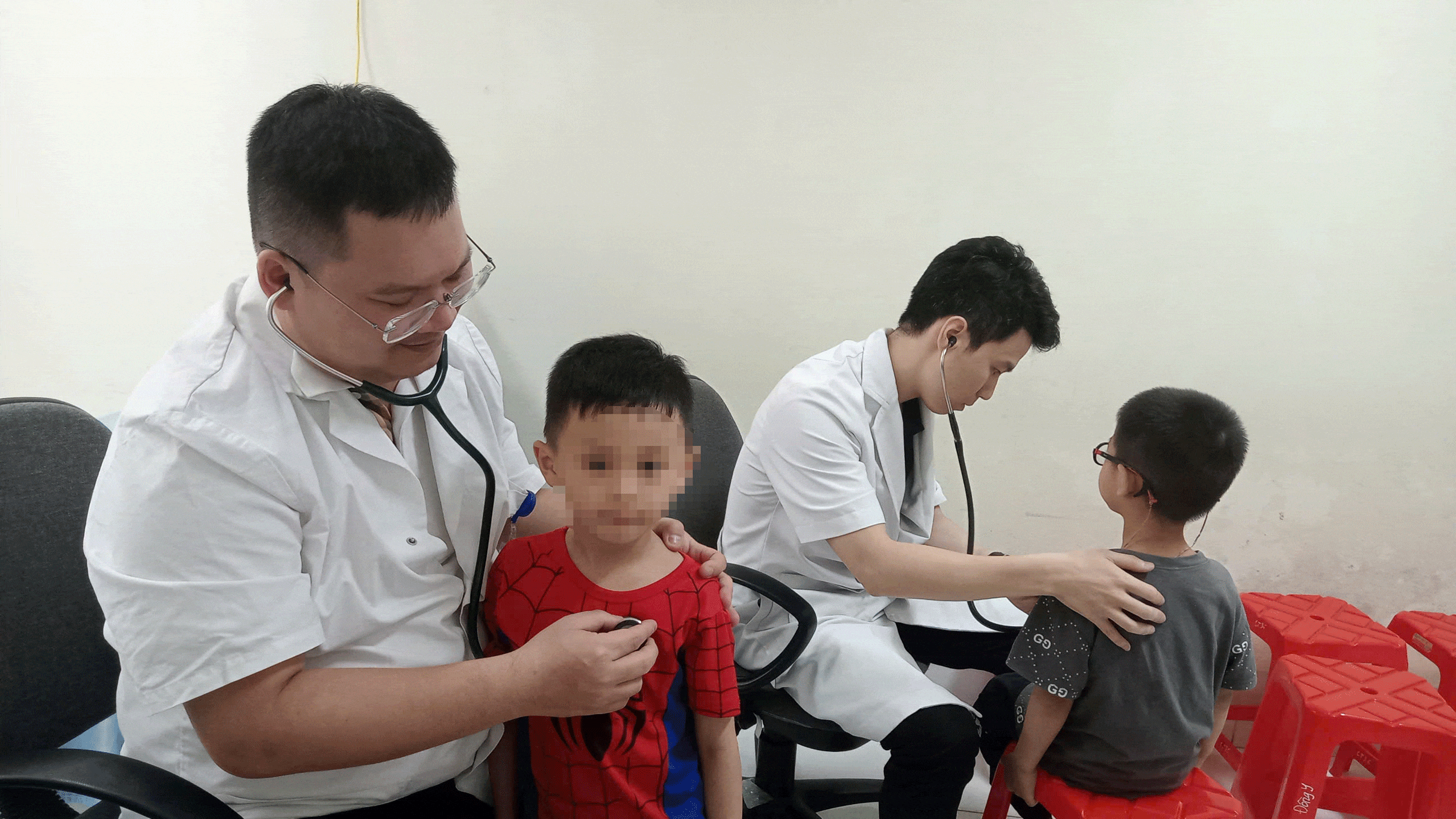 Các bác sĩ khám sàng lọc cho bệnh nhi. z6614089392445-315ea1cedff3.gif