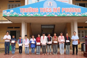 Lãnh đạo Hội Văn học nghệ thuật tỉnh trao quà cho học sinh nghèo vượt khó Trường THCS Mỹ Phương.