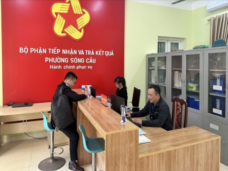 Cán bộ hỗ trợ người dân giải quyết các thủ tục hành chính tại Bộ phận tiếp nhận và trả kết quả phường Sông Cầu (TP. Bắc Kạn). 1234544.jpg