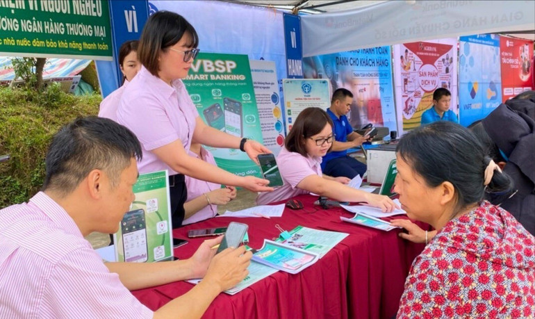 Cán bộ Phòng Giao dịch NHCSXH huyện Chợ Đồn giới thiệu các chương trình tín dụng ưu đãi và hướng dẫn cài đặt ứng dụng trên điện thoại cho người dân. 1-789.jpg