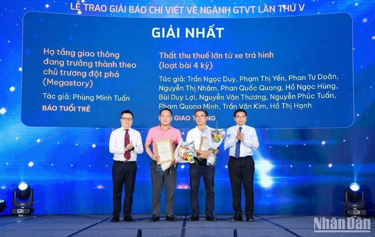 Đồng chí Lê Quốc Minh, Ủy viên Trung ương Đảng, Tổng Biên tập Báo Nhân Dân, Phó Trưởng ban Tuyên giáo Trung ương, Chủ tịch Hội Nhà báo Việt Nam và đồng chí Nguyễn Văn Thắng, Ủy viên Trung ương Đảng, Bộ trưởng Giao thông vận tải trao giải Nhất cho các tác giả. (Ảnh: Tạ Hải) 2222-4636-4447.jpg