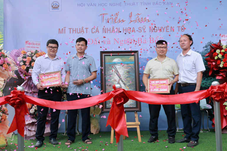 Author Ha Nguyen To (far right) presents donations from the auction of paintings to the representative of the Vietnam Fatherland Front Committee of Ba Be district. z6678077908186-764c8cc2c3a120ddbe43a8dcd139b621.jpg