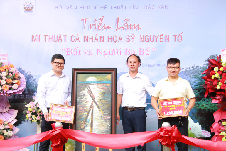 Họa sĩ Hà Nguyên Tố trao tranh cho 2 đại biểu đấu giá bức tranh “Thuyền độc mộc trên hồ Ba Bể”. img-1750.jpg
