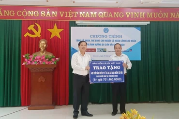 Phó Tổng Giám đốc BHXH Việt Nam, Chu Mạnh Sinh trao biển tượng trưng số tiền tặng sổ, thẻ cho đại diện UBND thành phố Bắc Kạn