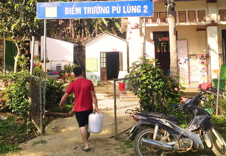 Mỗi sáng các phụ huynh ngoài chở theo con đến lớp còn mang theo một can nước. 02.gif