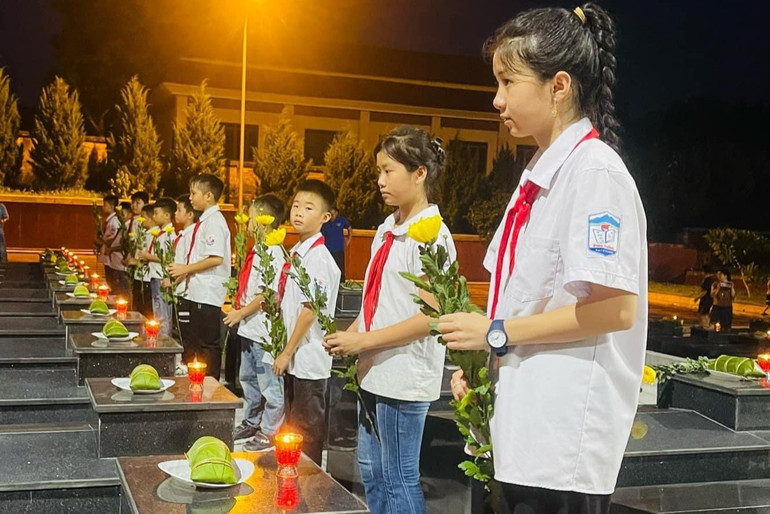 Các em học sinh dâng hoa tại các phần mộ liệt sĩ. z5671614963268_4cb73f379ffafcf742a9367a48df833e.jpg