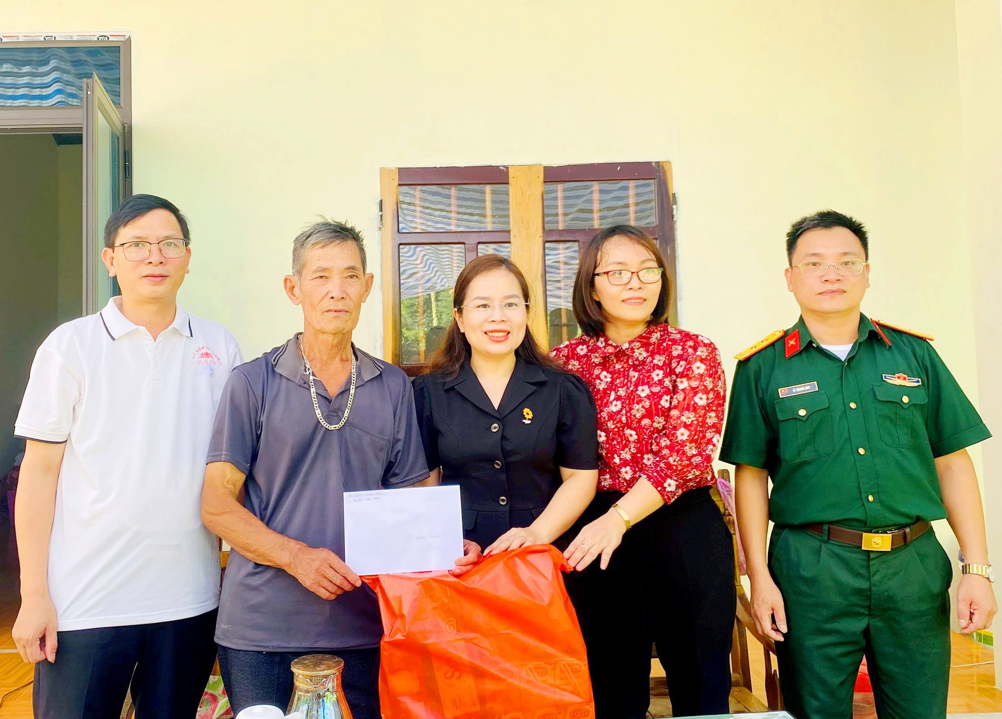 Bà Ma Thị Mận, Phó Bí thư Thường trực Huyện ủy Pác Nặm tặng quà ông Bàn Văn Ton là người hoạt động kháng chiến bị nhiễm chất độc hóa học ở thôn Nà Mặn, xã Công Bằng (Pác Nặm). z5670428271197_9017f083bc09c7d86e7dedaee1280e6a.jpg