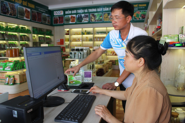 Anh Thuận, chủ cửa hàng giới thiệu, bán sản phẩm OCOP hướng dẫn nhân viên áp dụng công nghệ trong thanh toán đơn hàng. img-0089.jpg